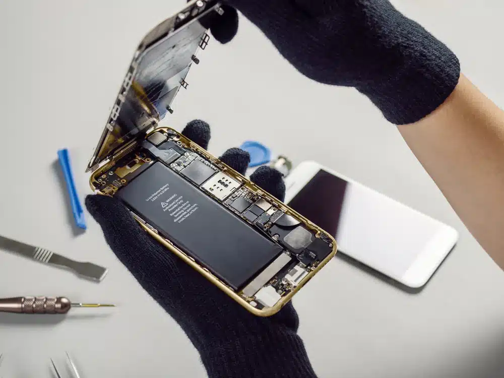 Technik iDoctor wymieniający baterię w smartfonie iPhone 11