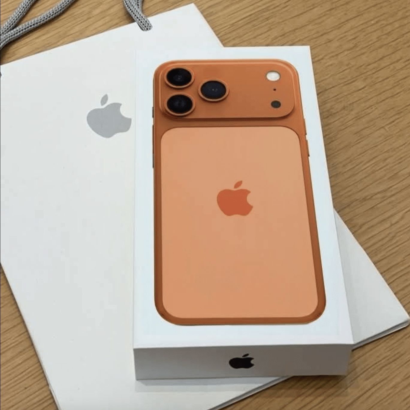 Porównanie różnych modeli telefonów iPhone na tle logo Apple